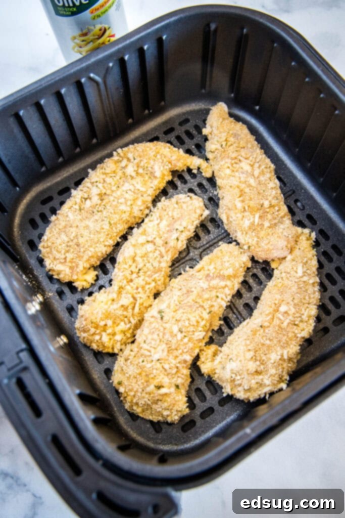 Crispy Air Fryer Chicken Tenders 4 Air fried chicken tenders ready in an air fryer basket