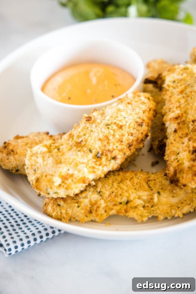 Crispy Air Fryer Chicken Tenders 5 Crunchy chicken tenders cooked in air fryer on a plate with dipping sauce