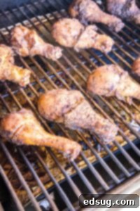 Chicken legs cooking on the grill, getting char marks for flavor and texture