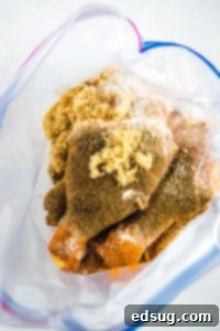 Adding spices to chicken drumsticks in a ziplock bag for even coating