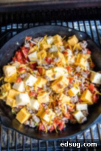 putting pan of queso ingredients on smoker