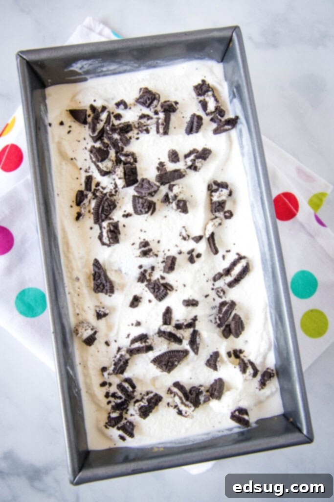 Top-down view of a loaf pan filled with homemade Cookies and Cream Ice Cream, ready for freezing.