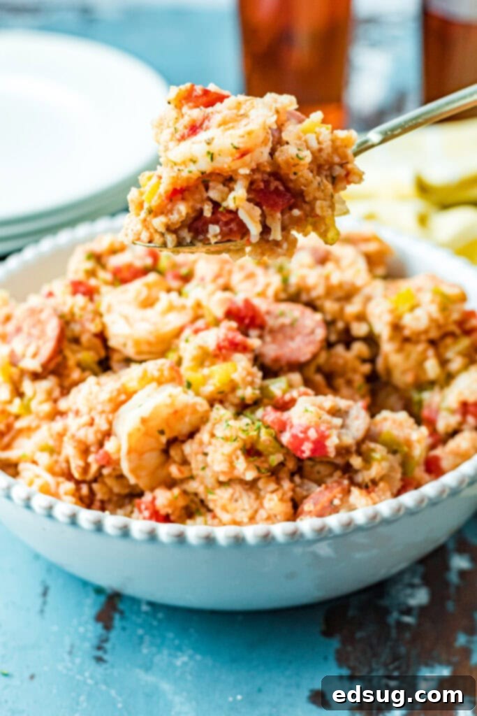 A close-up shot of a spoonful of slow cooker jambalaya with chicken, sausage, and shrimp.