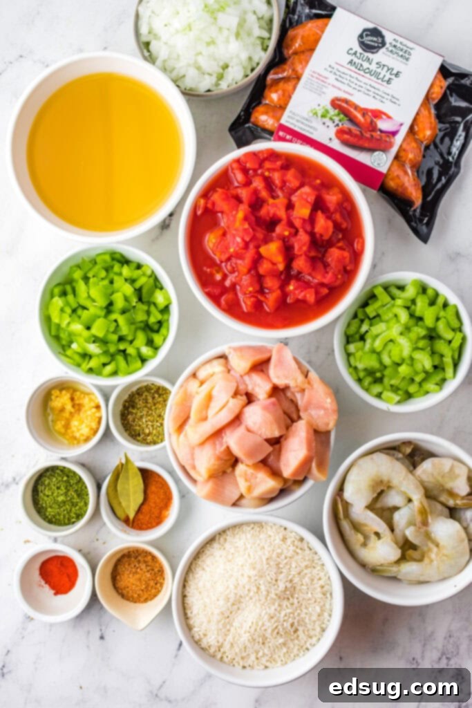 Raw ingredients laid out for slow cooker jambalaya, including chicken, sausage, shrimp, vegetables, and spices.