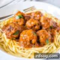 Close up view of perfectly cooked Instant Pot Meatballs over spaghetti in marinara sauce.
