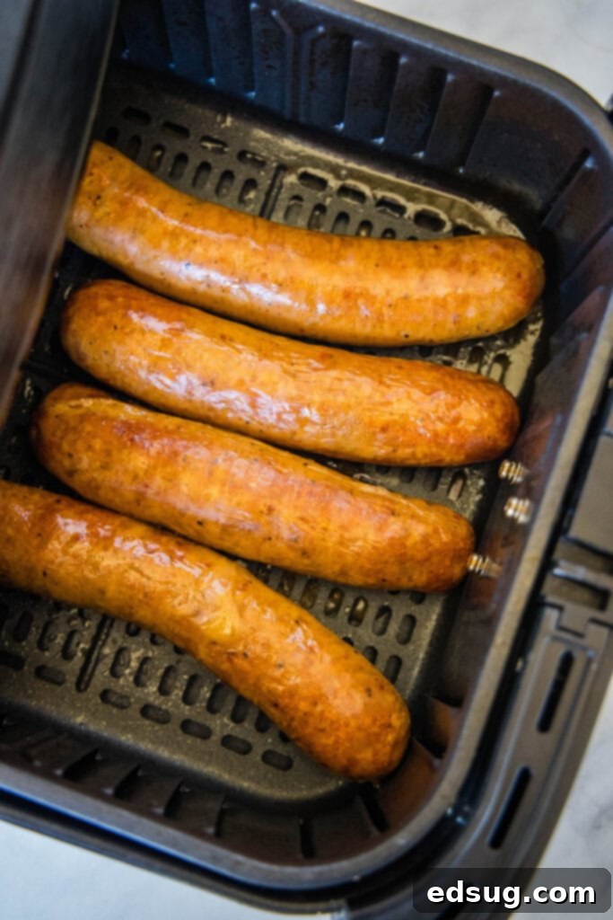 Perfectly cooked and browned sausages nestled in an air fryer basket, ready to be served.