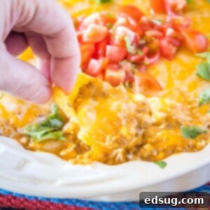 Molten Chili Cheese Delight 6 close up using a chip to scoop out chili cheese dip