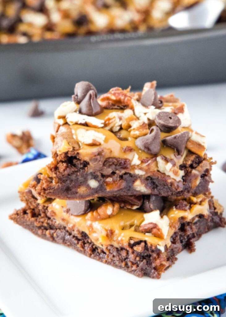 brownies with pecans, caramel and chocolate stacked on a plate