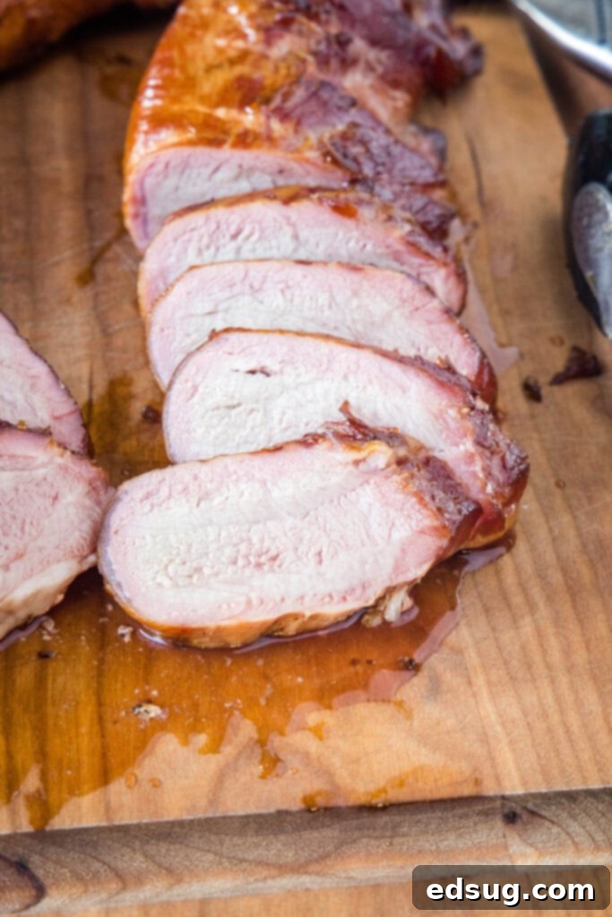 Succulent Smoked Pork Tenderloin 2 sliced pork tenderloin on a cutting board