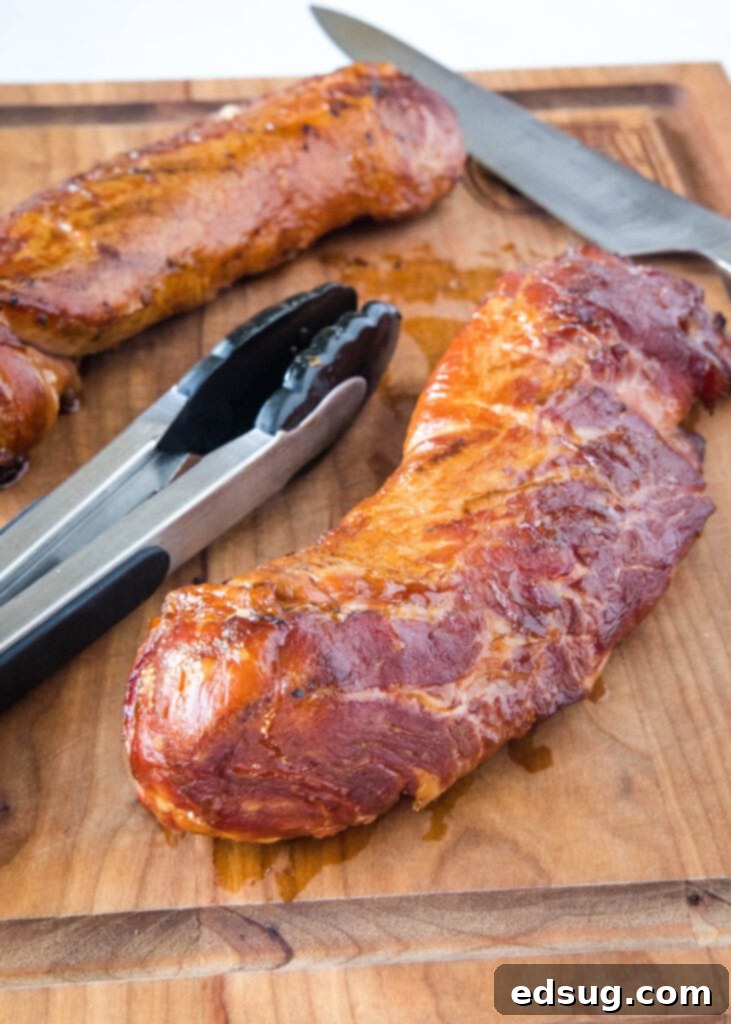 Succulent Smoked Pork Tenderloin 4 smoked pork tenderloin on a cutting board with a knife