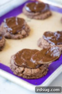 spreading chocolate ganache on cookies