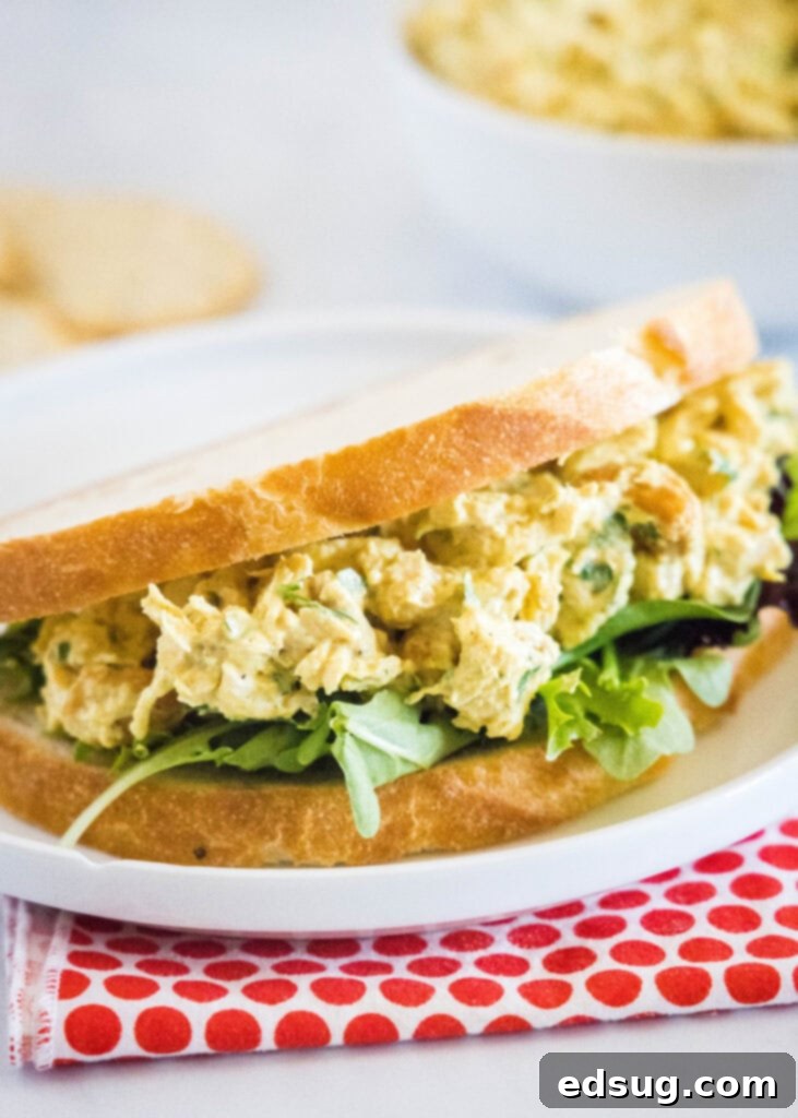 Curry chicken salad served on toasted bread with fresh greens.