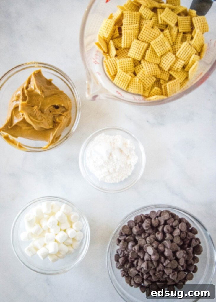 Ingredients for Puppy Chow Bars laid out on a counter, including Chex cereal, chocolate chips, peanut butter, marshmallows, and powdered sugar.