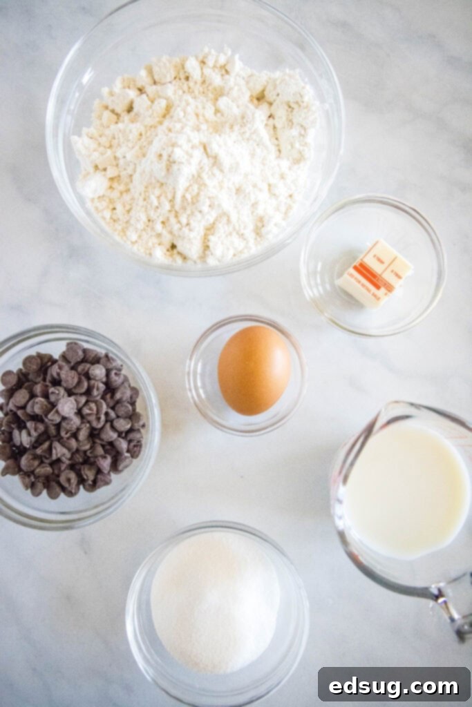 A bowl filled with Bisquick muffin ingredients, including the mix, sugar, milk, egg, and melted butter, ready for combining.