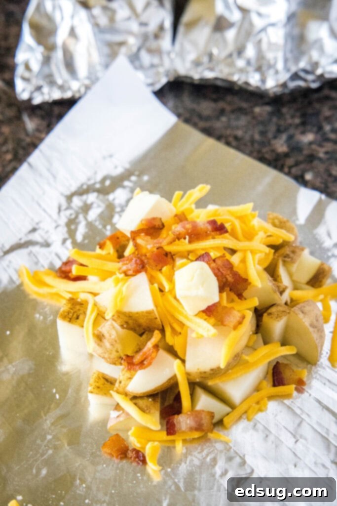 Diced potatoes, cheese, and bacon being assembled into a foil pack.