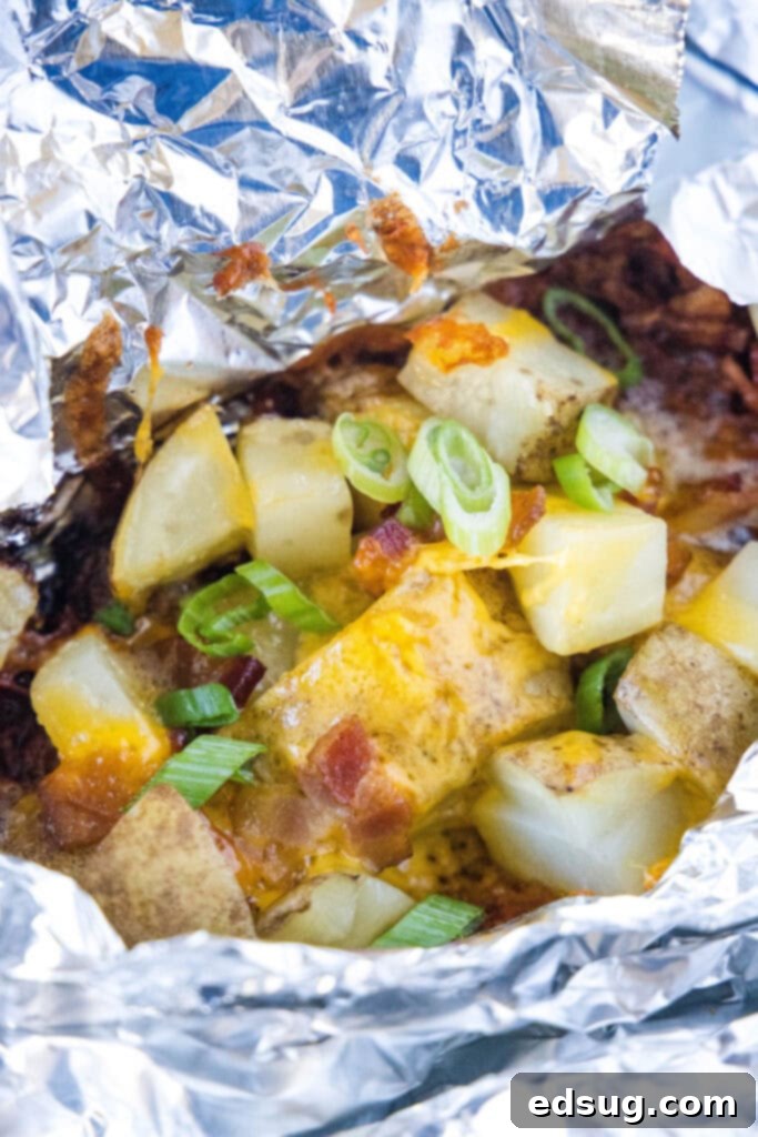 Open foil pack revealing tender, cheesy, bacon-filled potatoes.