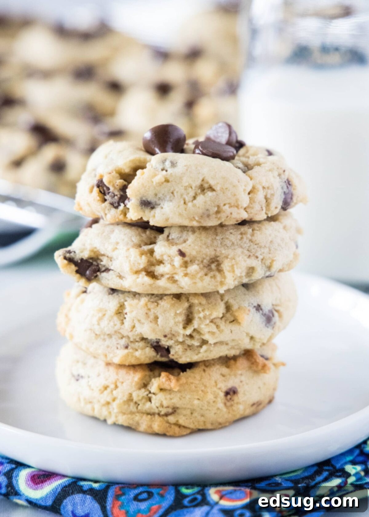 A stack of four perfectly baked cream cheese chocolate chip cookies, showing their soft texture.