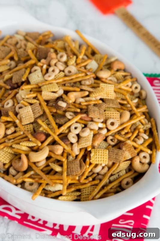 A rustic basket overflowing with golden-brown Chex Party Mix, featuring a mix of cereals, pretzels, and nuts, with a festive holiday background. SEO keywords: Chex Party Mix, Holiday Snack, Homemade.