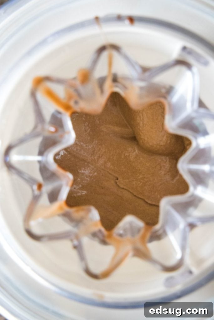 Churning homemade chocolate ice cream in an ice cream machine.
