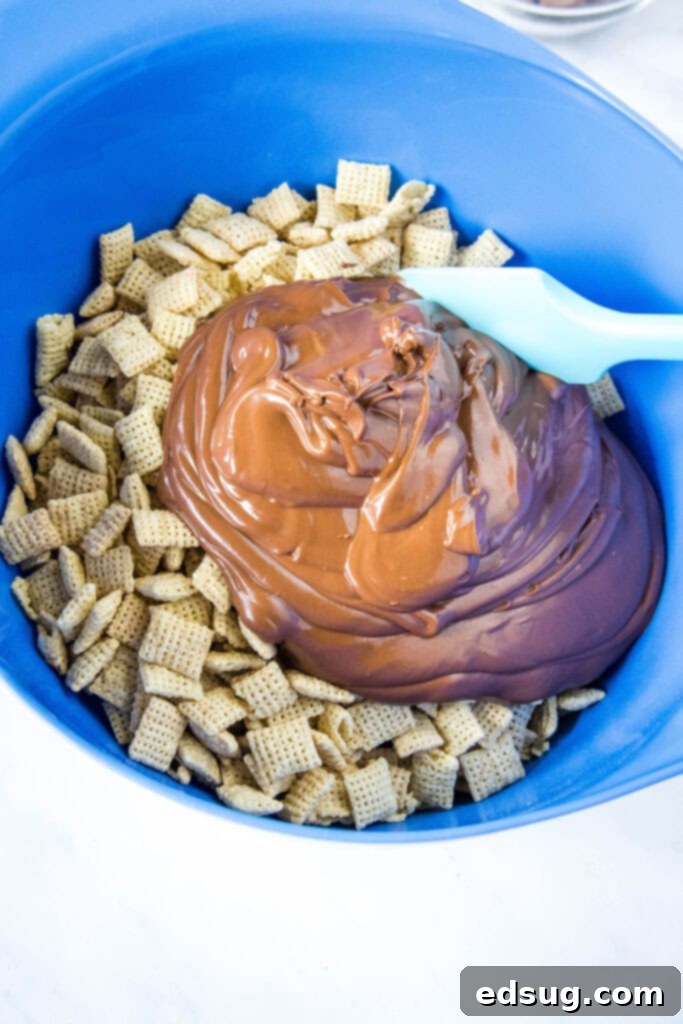 Spooky Puppy Chow 4 adding melted chocolate and peanut butter mixture to chex cereal in a large bowl
