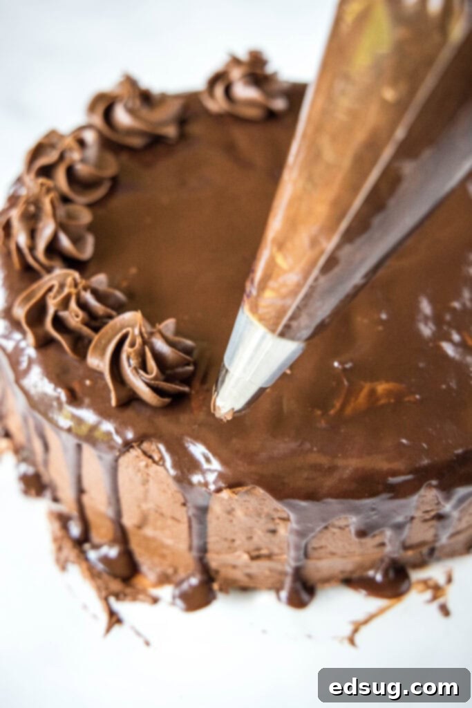 Ultimate Death By Chocolate Drip Cake 6 piping decorative chocolate swirls onto the top of a drip cake