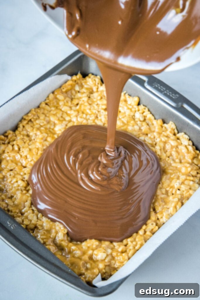 pouring melted chocolate on krispie treats