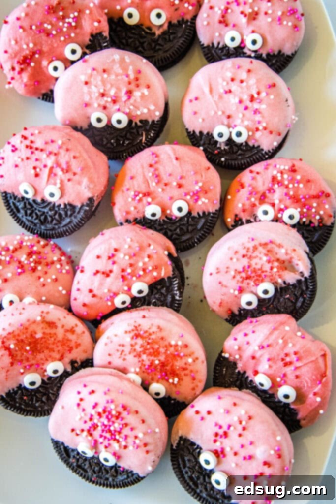 An inviting overhead view of a diverse plate of Love Bug Oreo Cookies, each uniquely adorned with various sprinkles and candy eyes, showcasing their individual charm and festive appeal.
