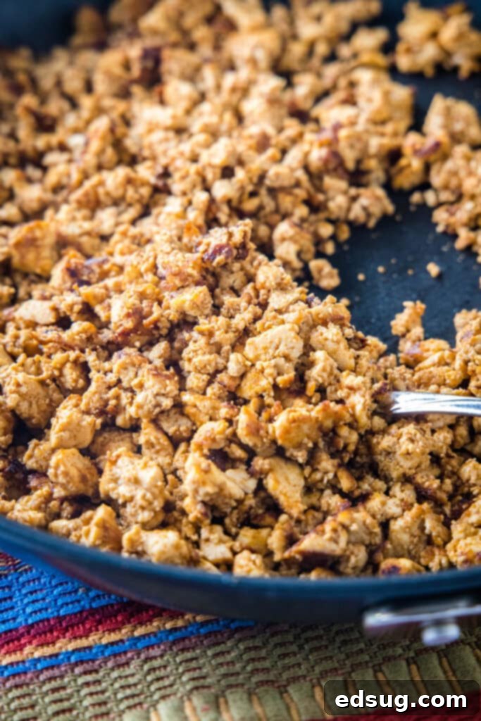 The seasoned tofu taco filling actively cooking in a hot skillet, with visible browning edges.