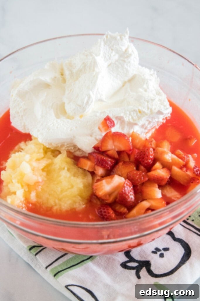 Strawberry fluff ingredients combined in a bowl, before marshmallows are added.