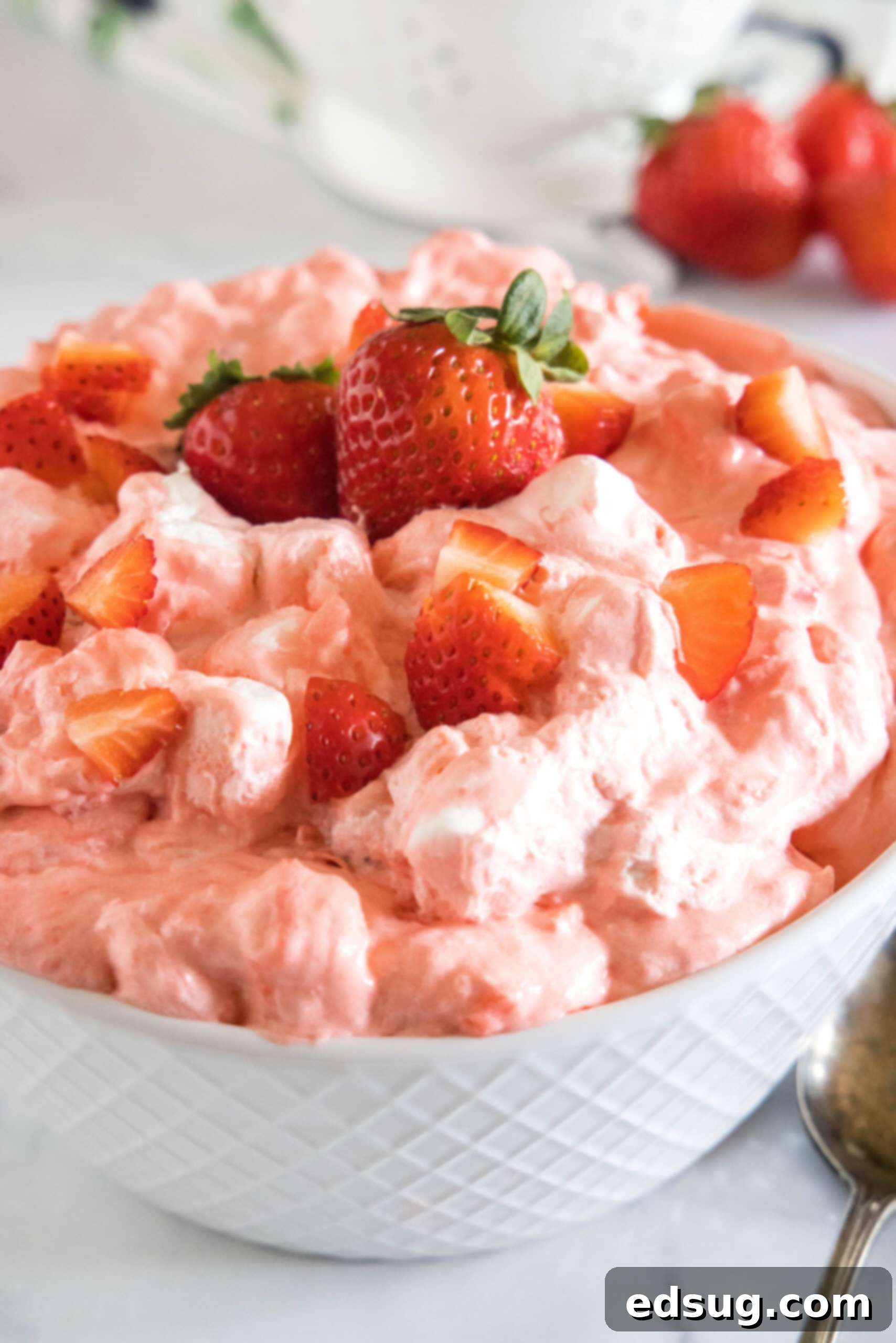 Close-up of strawberry fluff in a white bowl, showcasing its creamy texture and fresh strawberry chunks.