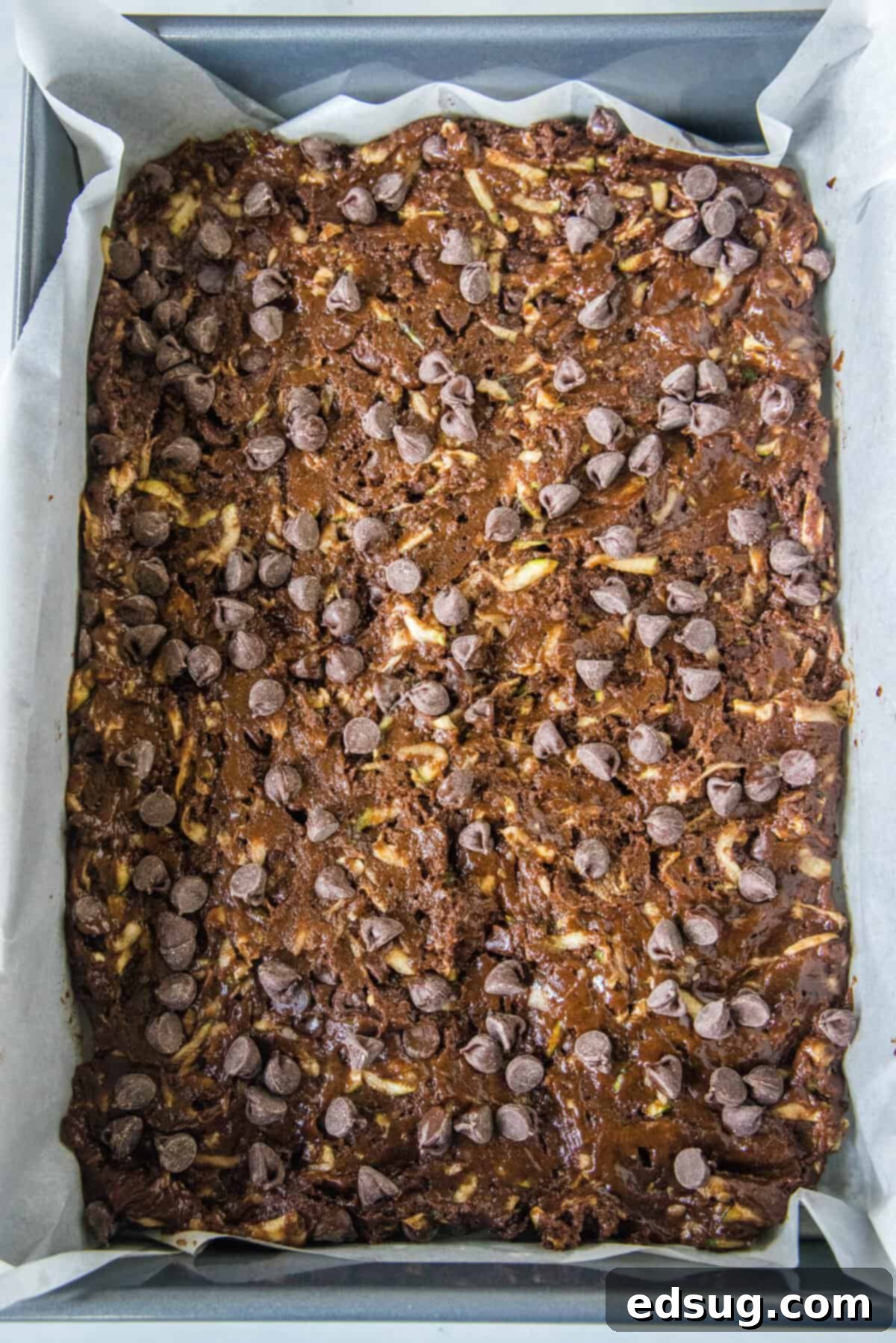 Zucchini brownie batter spread evenly in a prepared baking pan