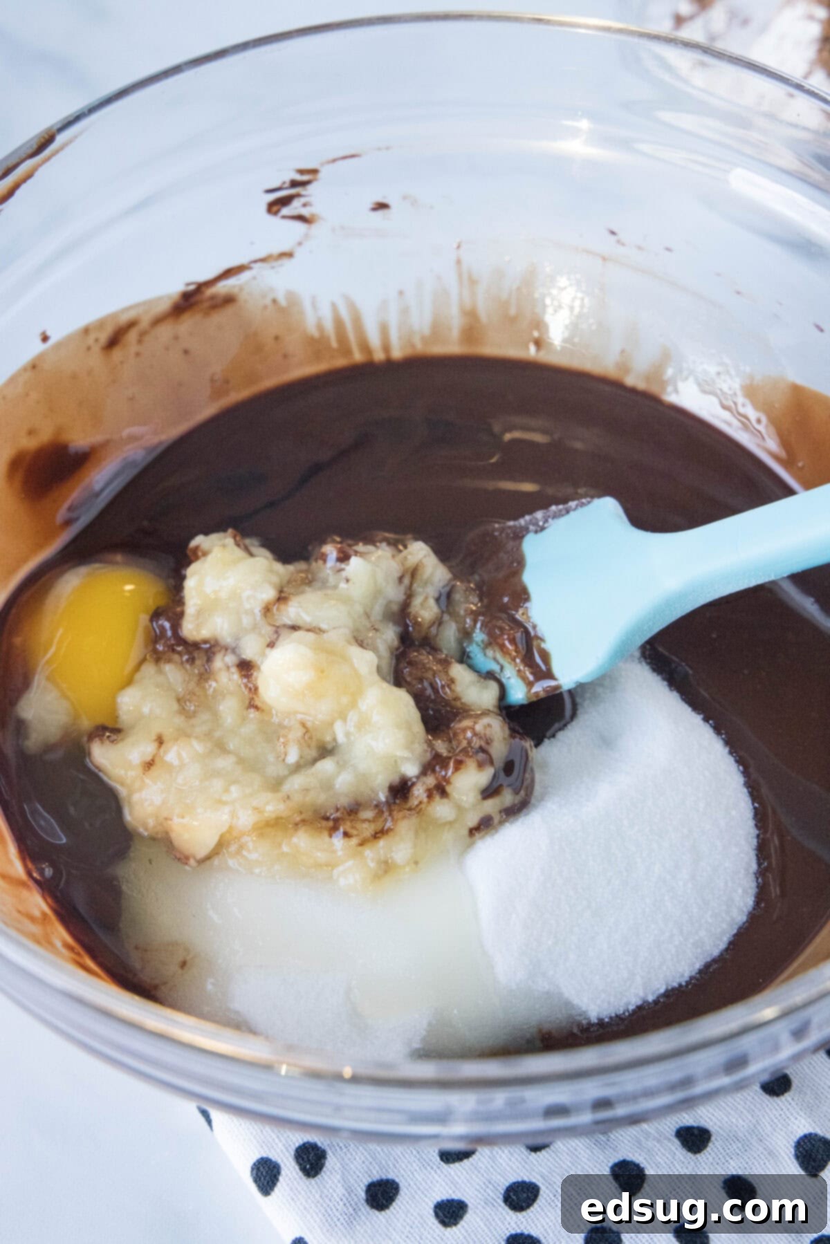mixing banana brownie ingredients together in a large glass bowl