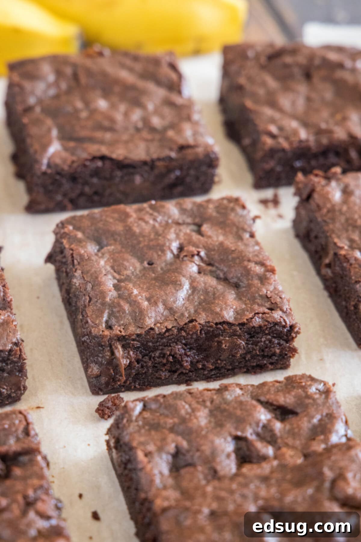 Sliced fudgy banana brownies cooling on a cutting board, showing their rich texture.