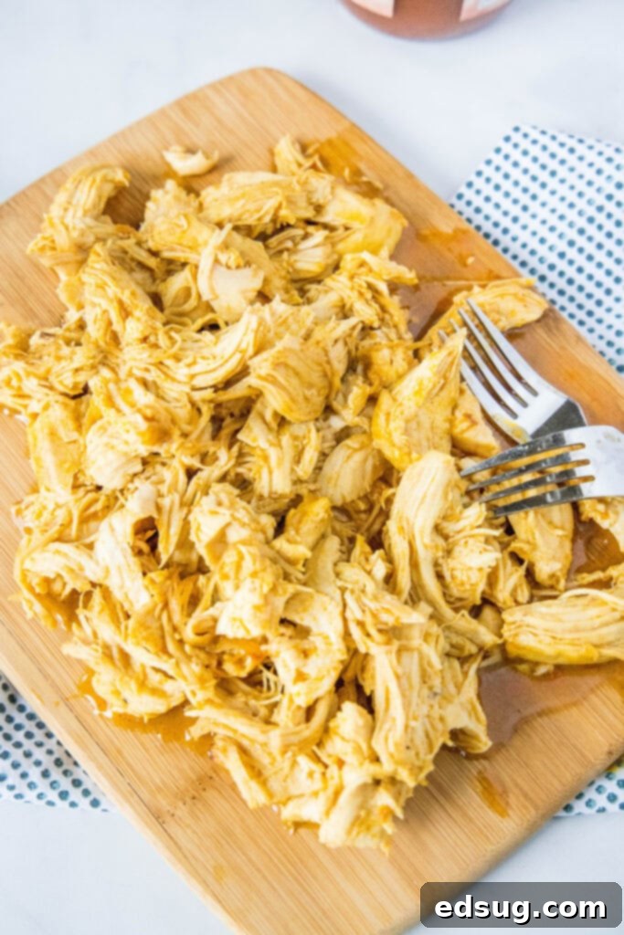 looking down on shredded chicken on a cutting board