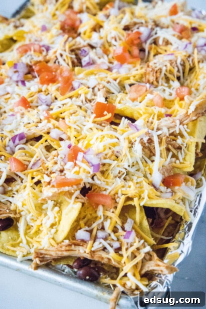 bbq chicken nachos on a baking tray ready for the oven