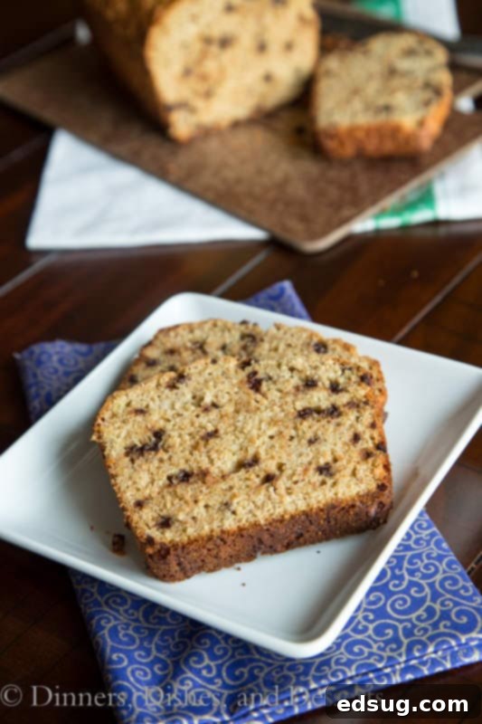 a freshly baked loaf of whole wheat chocolate chip banana bread on a wooden board