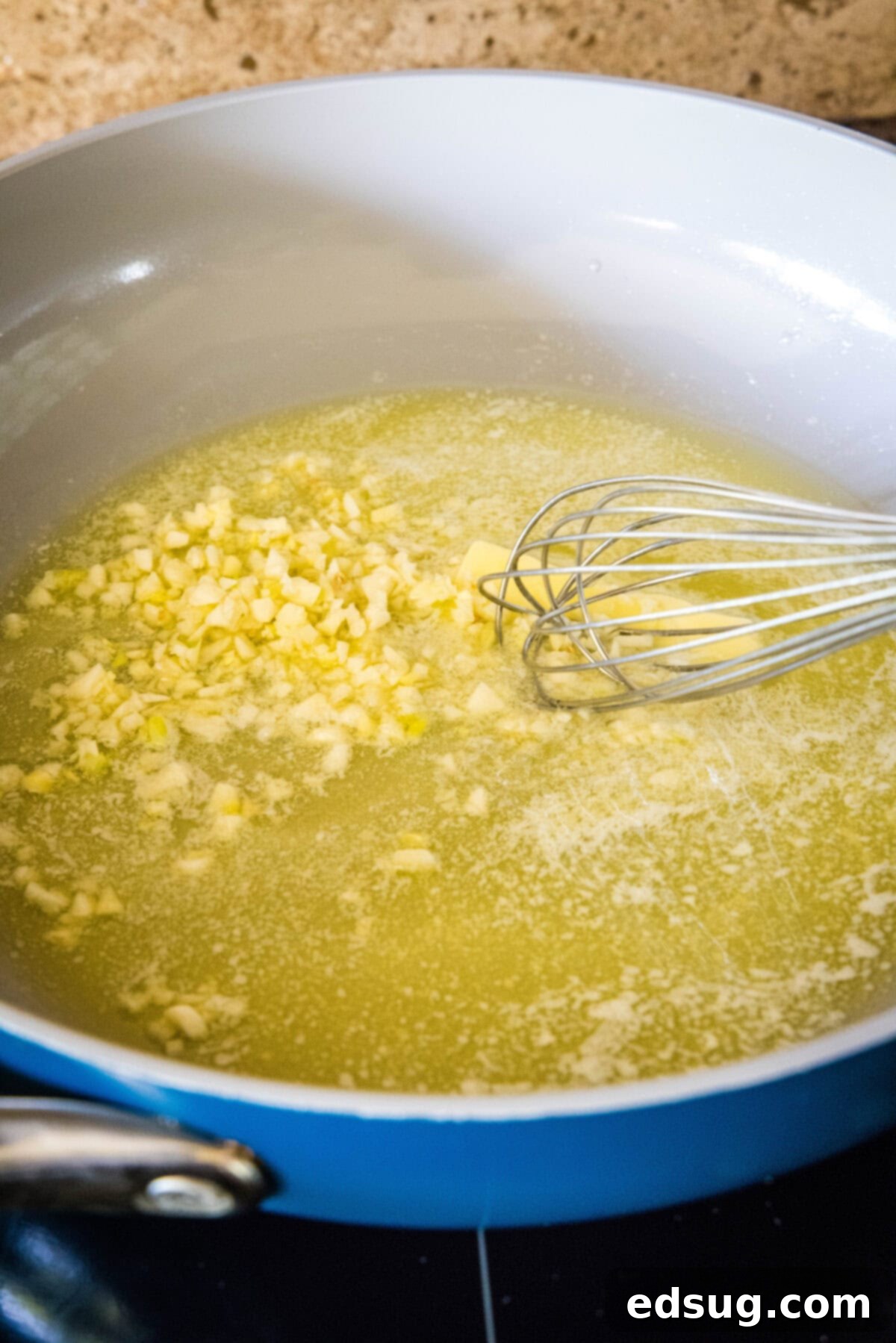 This easy homemade Alfredo sauce is rich and creamy and packed with garlicky parmesan flavors. Make it in one pan with your favorite pasta! Minced garlic added to melted butter in a skillet.