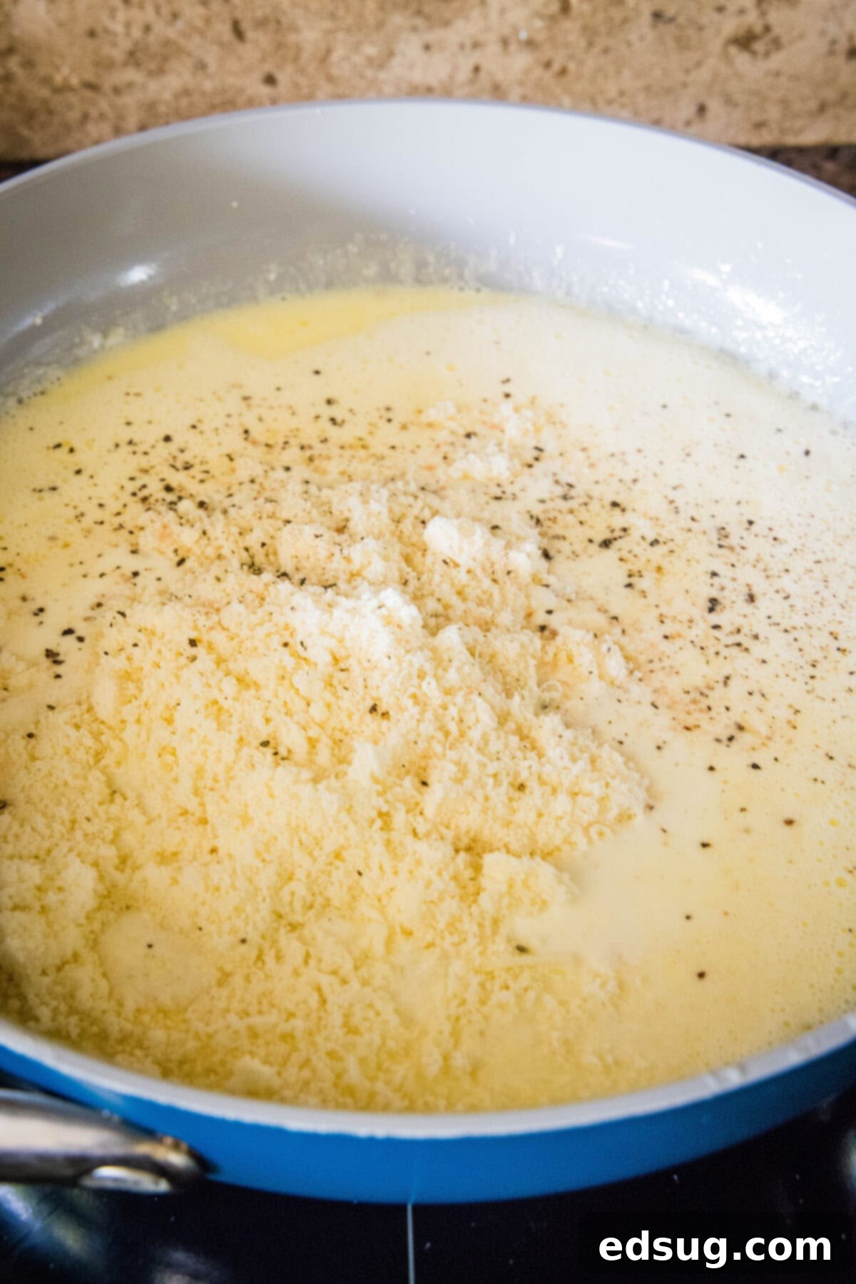 This easy homemade Alfredo sauce is rich and creamy and packed with garlicky parmesan flavors. Make it in one pan with your favorite pasta! Parmesan cheese and heavy cream added to melted butter and garlic in a skillet.