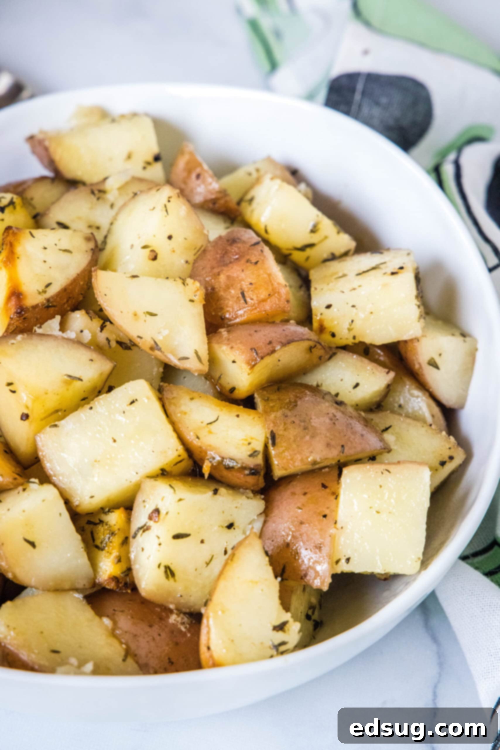 A bowl of slow cooker potatoes garnished with fresh parsley on a wooden surface.