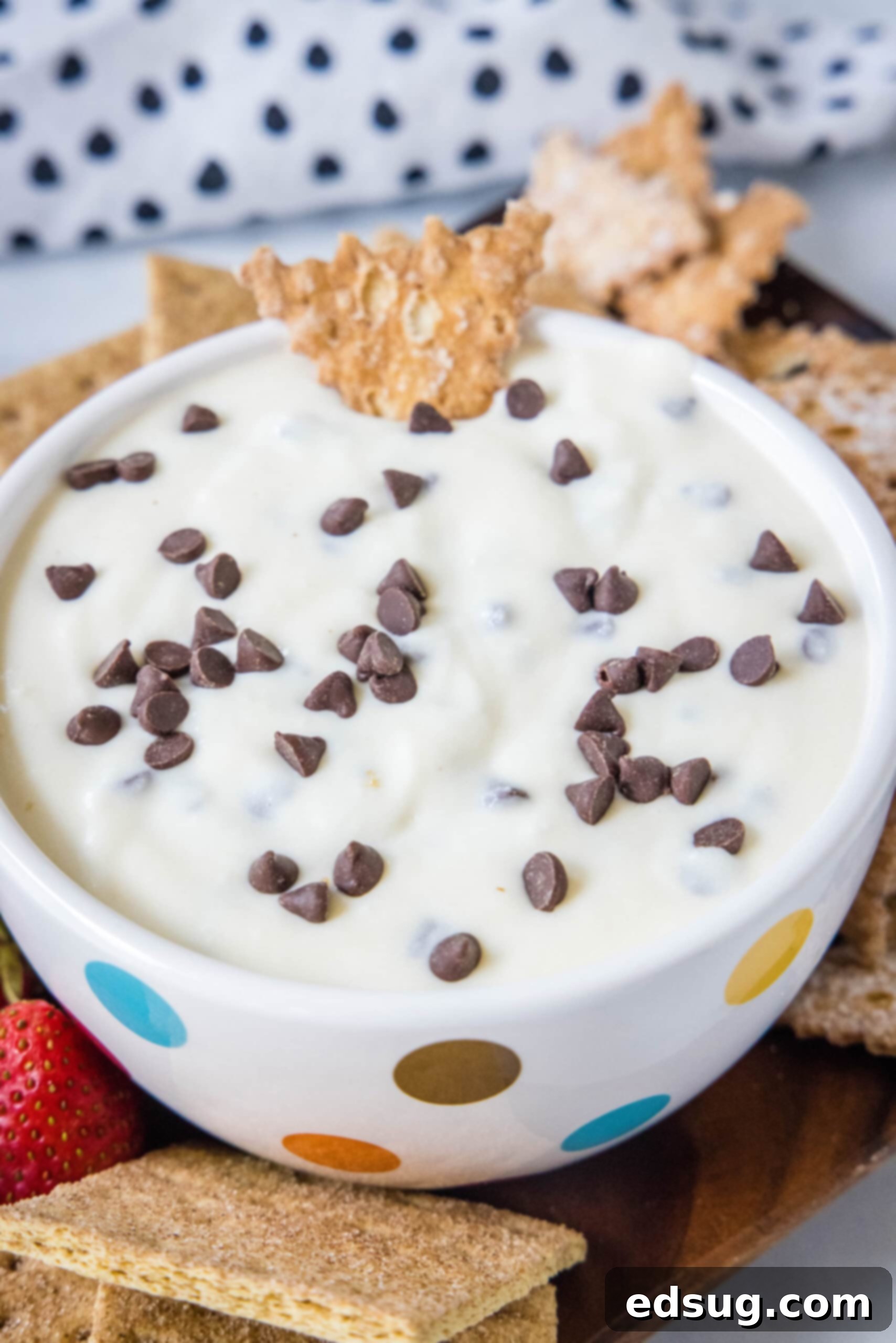 A beautifully presented bowl of creamy cannoli dip, ready to be enjoyed, with a single graham cracker dipped in, highlighting its inviting texture.