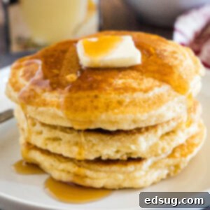 Festive Eggnog Pancakes 8 Close up stack of eggnog pancakes on a white plate with syrup
