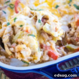 A serving of chicken fajita casserole being scooped from a baking dish.