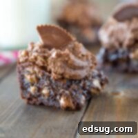 Peanut butter brownies with peanut butter cup frosting on a board