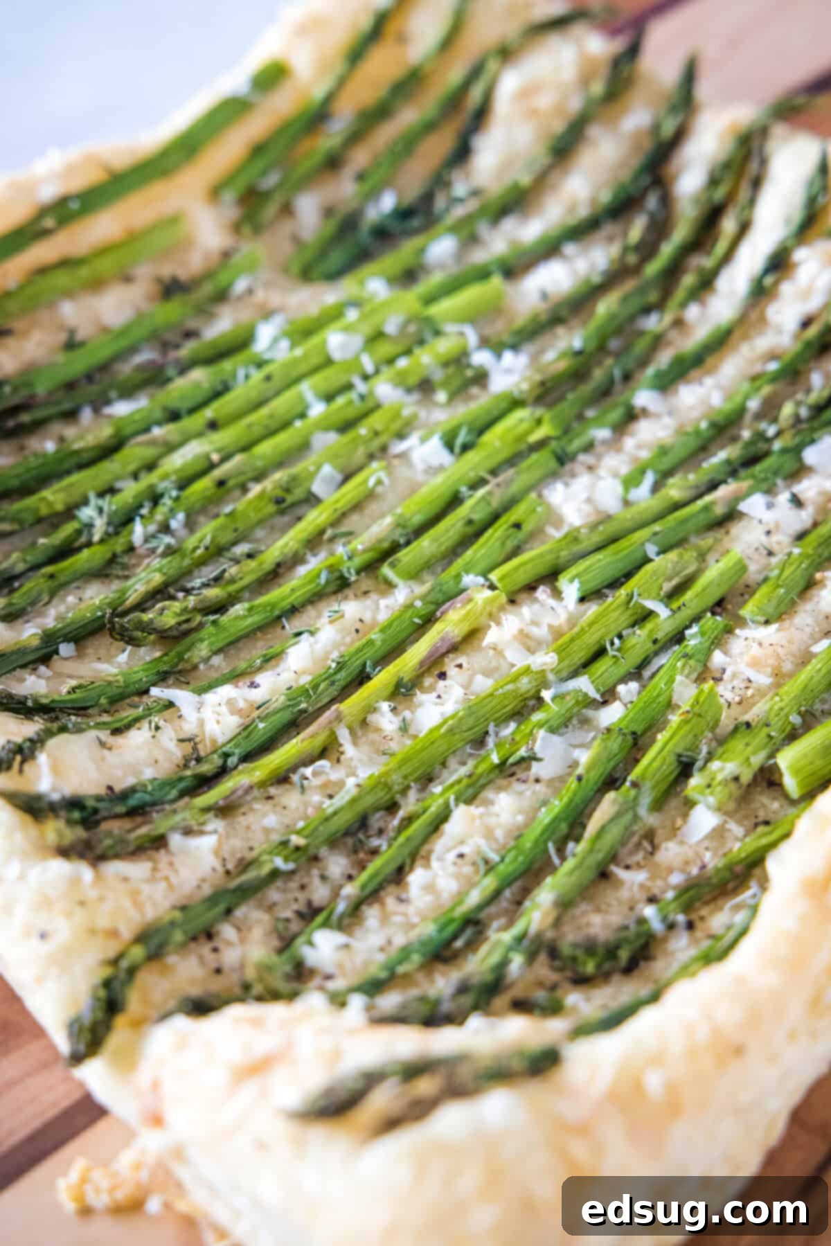 another view of asparagus tart baked on a cutting board, ready for serving