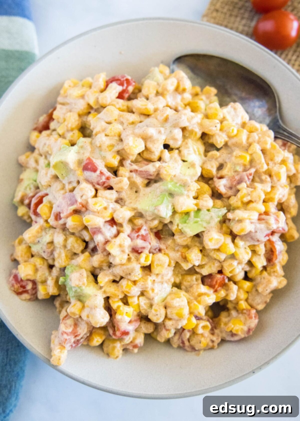 Overhead view of a bowl of corn salad with a spoon