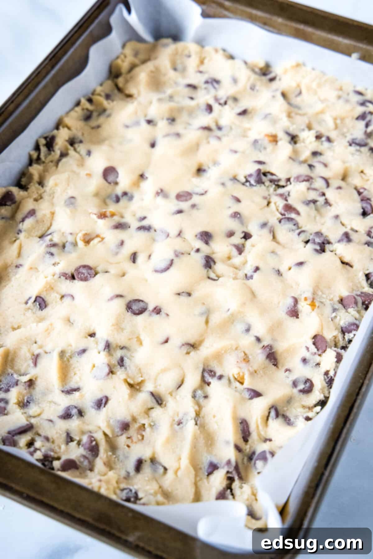 Congo bars are thick and gooey cookie bars loaded with two types of chocolate and crunchy walnuts. Make them in one bowl in minutes! The smooth, chocolatey Congo bar batter evenly spread into a prepared baking pan, ready for the oven.