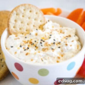 cropped close bowl of everything bagel dip with a cracker