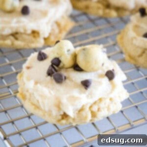 Close up of frosted cookie dough cookies on a wire rack.