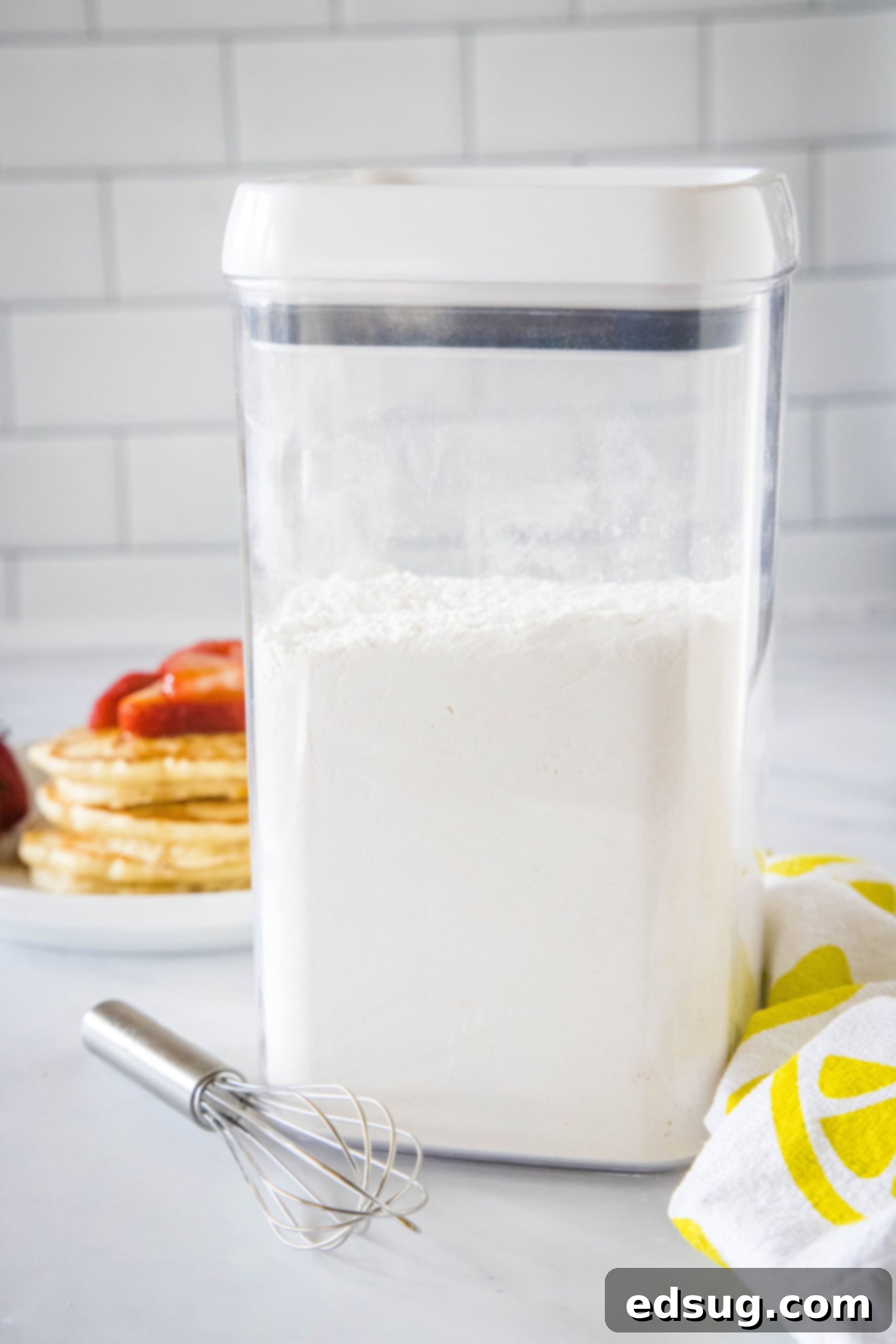 Homemade pancake mix stored in an airtight glass jar on a kitchen countertop, ready for use.