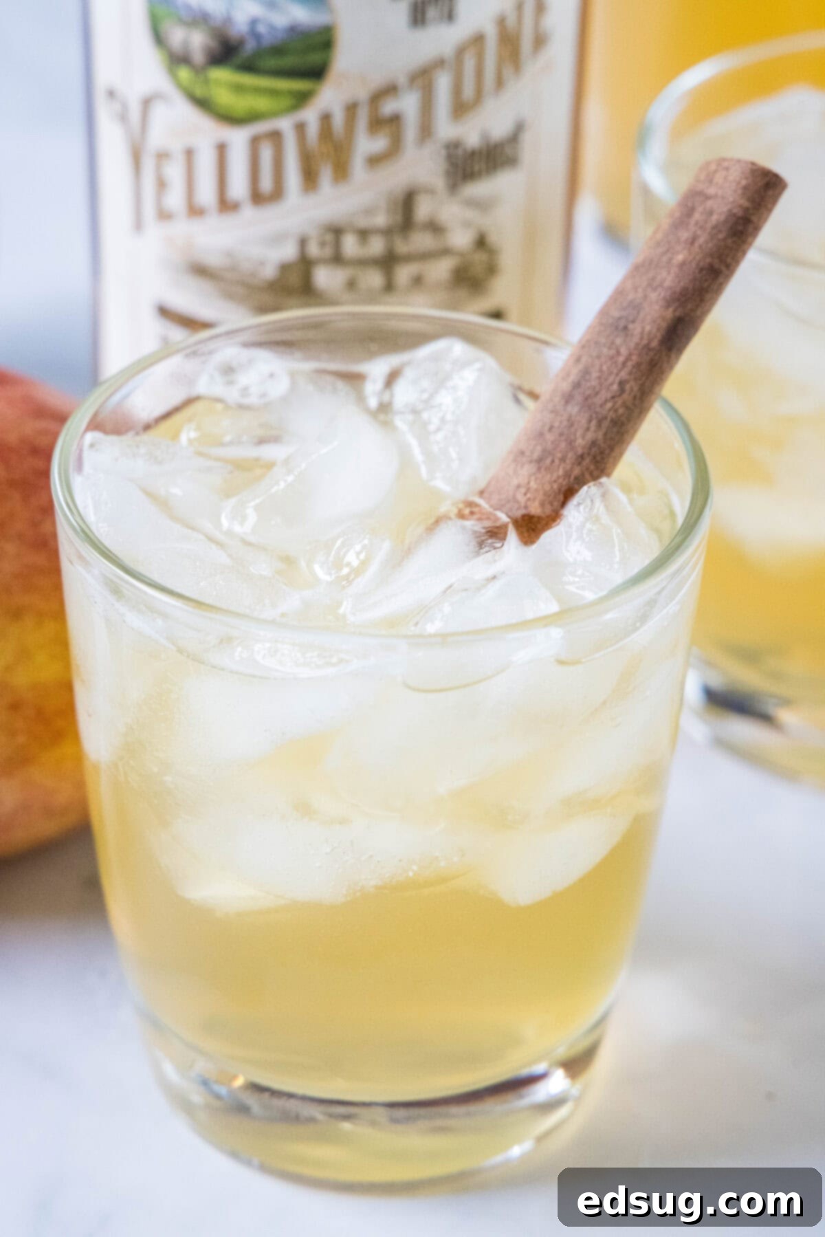 Close-up of a Bourbon Apple Cider Cocktail in a glass with a cinnamon stick garnish